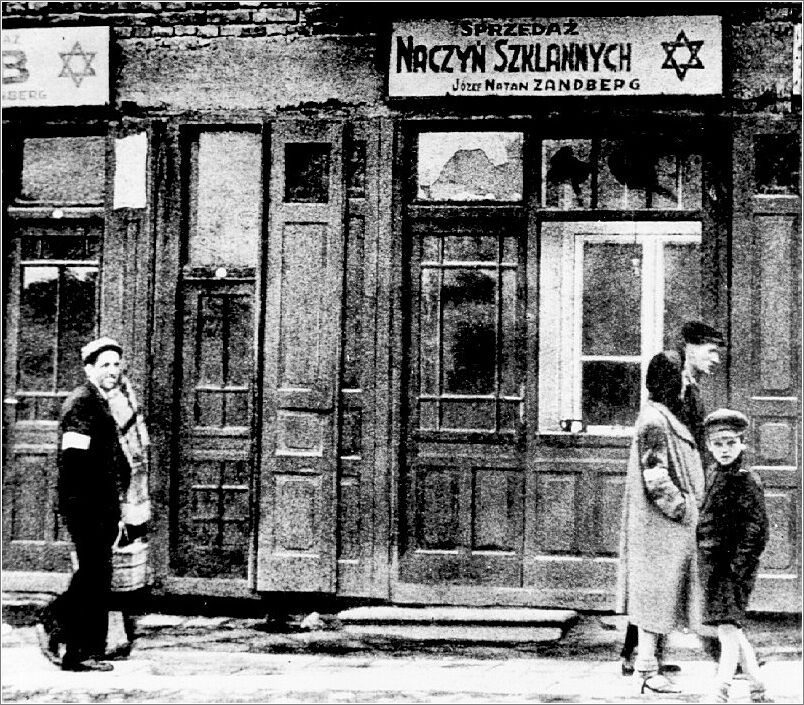 Jews on a street in the Radom ghetto, beside a glazier's shop.